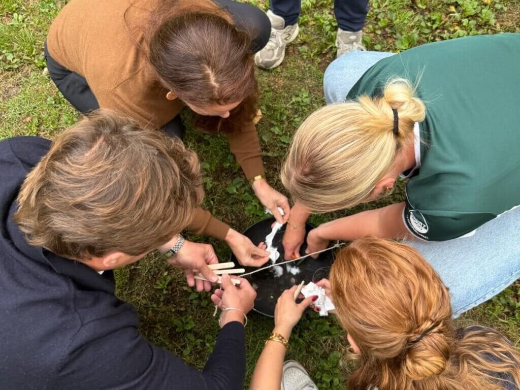 Vier deelnemers werken samen aan een teambuilding uitdaging tijdens een introductiedag van Move For Fun, met focus op communicatie en samenwerking.