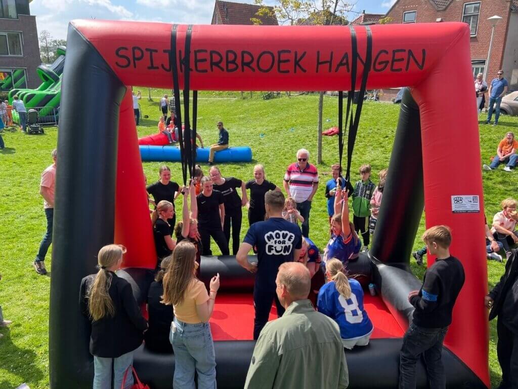 Kinderen doen enthousiast mee aan het spel Spijkerbroek hangen tijdens een zeskamp van Move For Fun