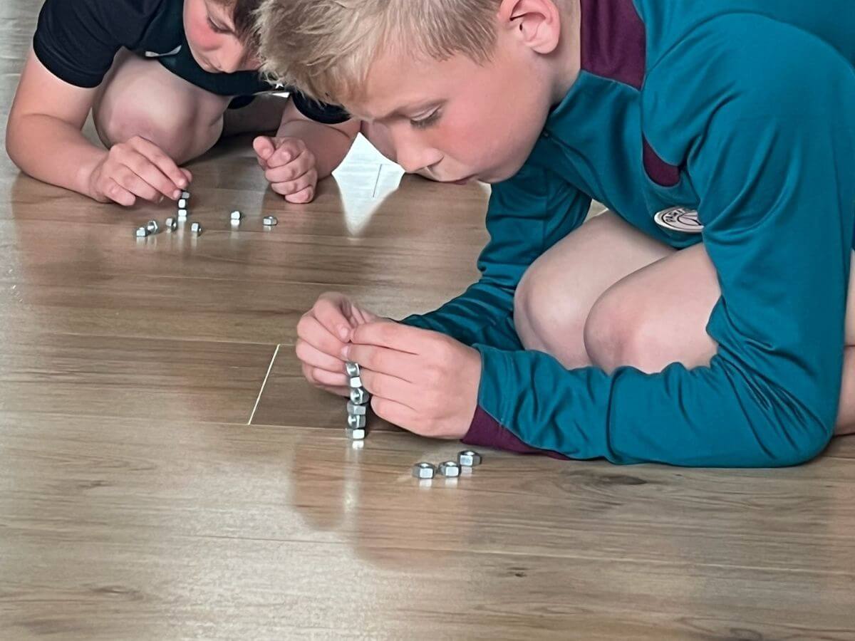 alleskunner-kinderfeestje-westland-moeren-stapelen Kinderen stapelen moertjes tijdens een concentratiespel bij het Alleskunner kinderfeestje.