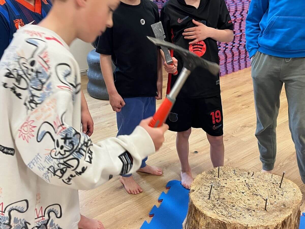alleskunner-kinderfeestje-westland-spijkerslaan-spel Kinderen slaan om de beurt spijkers in een boomstam bij het Alleskunner kinderfeestje.