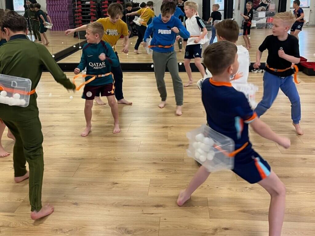 Kinderen spelen het twerkspel met pingpongballen tijdens het Alleskunner kinderfeestje.