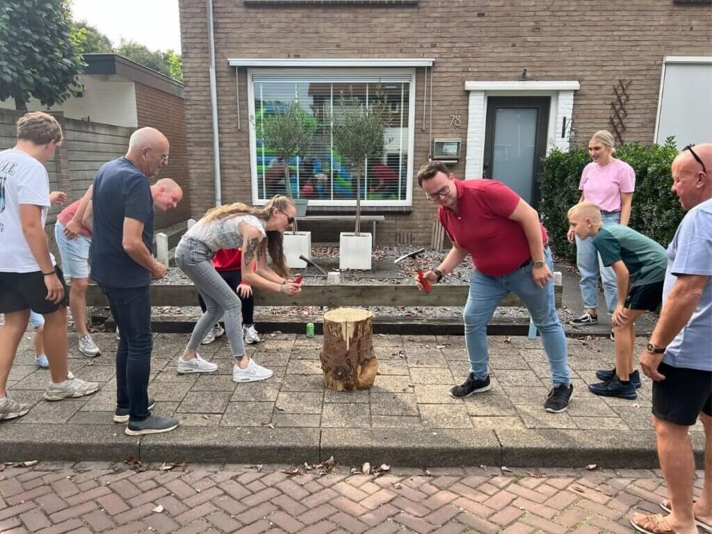 Deelnemers spelen het spijkerslaan spel tijdens een familiedag georganiseerd door Move For Fun.