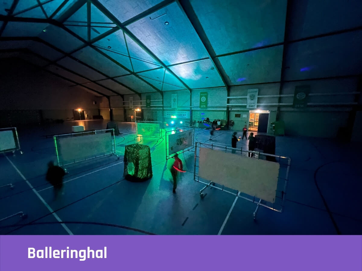 Kinderen spelen lasergame in de donkere Balleringhal met lichtshow tijdens een kinderfeestje