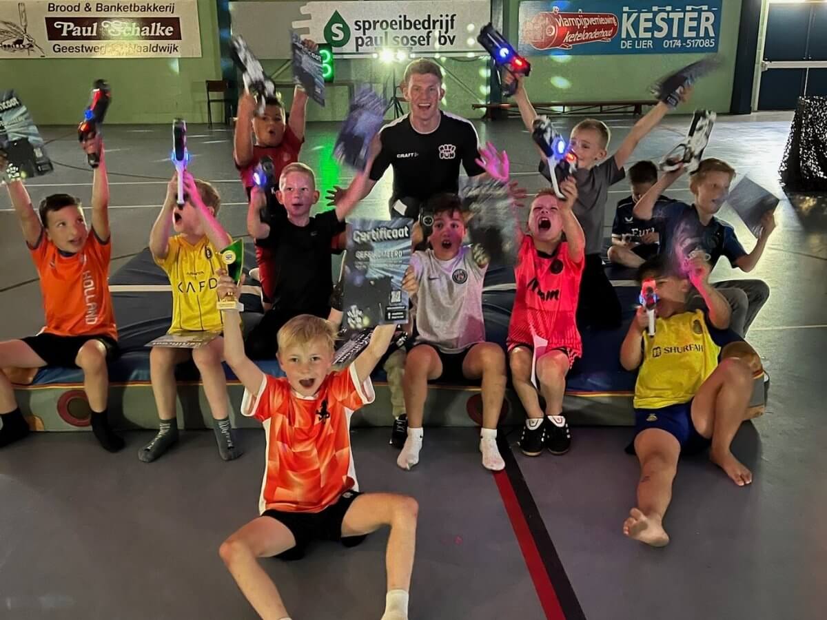 Lasergame Kinderfeestje – Groepsfoto Balleringhal Groep kinderen met certificaten en laserguns in de Balleringhal tijdens een lasergame kinderfeestje