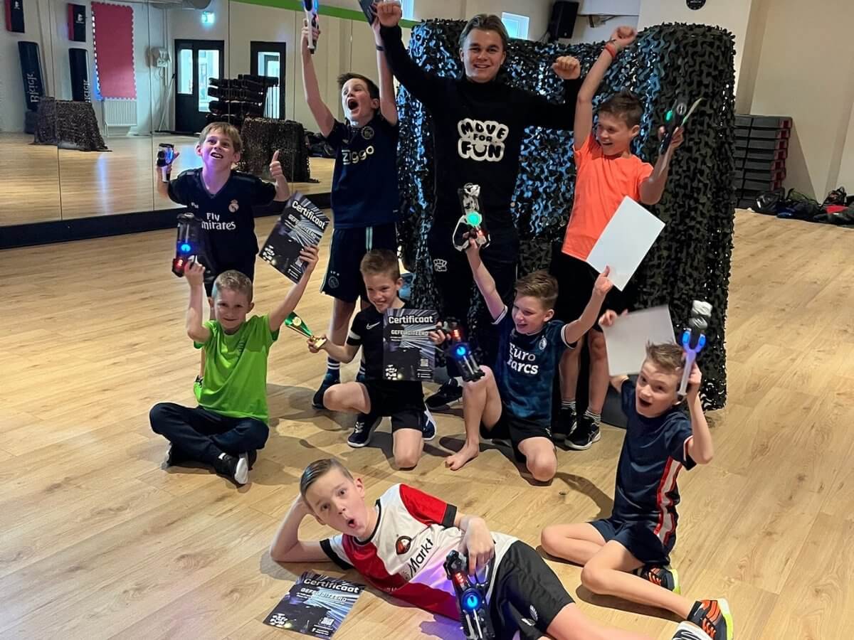 Lasergame Kinderfeestje – Groepsfoto Midexzaal Groep kinderen met laserguns tijdens een lasergame kinderfeestje in de Midexzaal