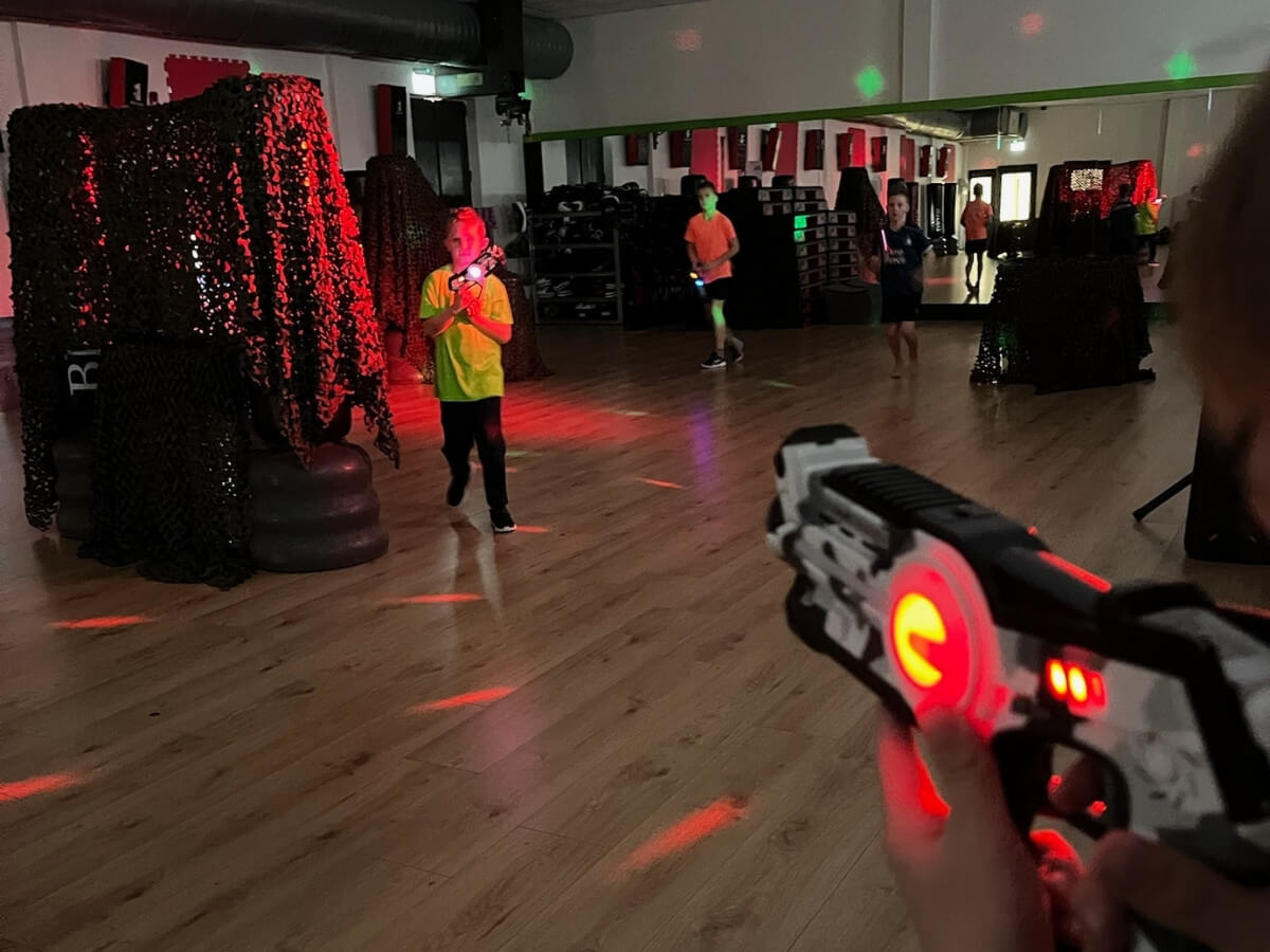 Lasergame Kinderfeestje – Midexzaal Westland Kinderen spelen lasergame in de donkere Midexzaal tijdens een kinderfeestje