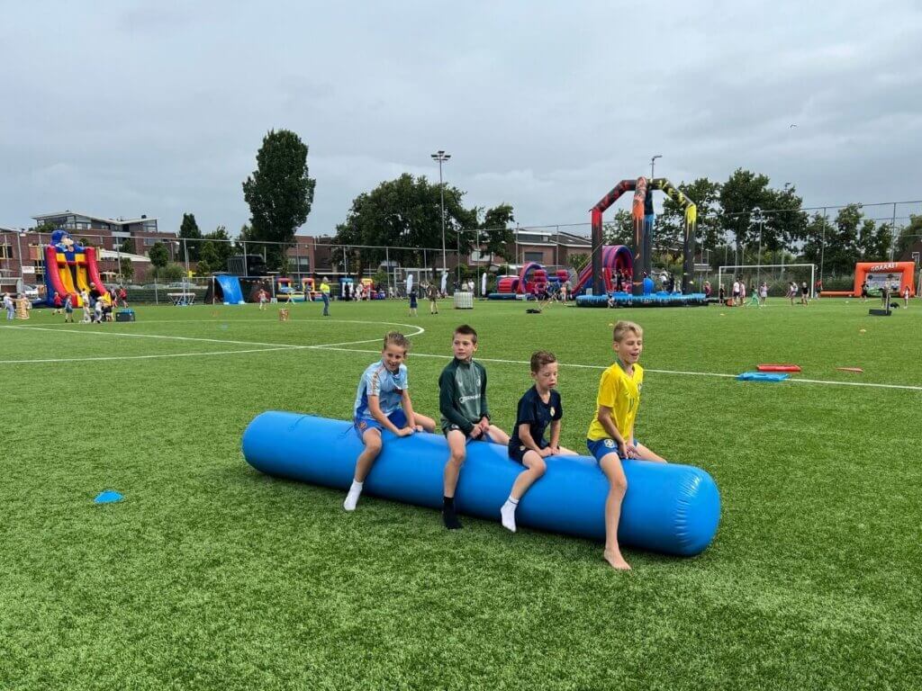 Kinderen racen op een skippyslang tijdens een sportieve seizoensafsluiting met spellen, springkussens en activiteiten van Move For Fun.