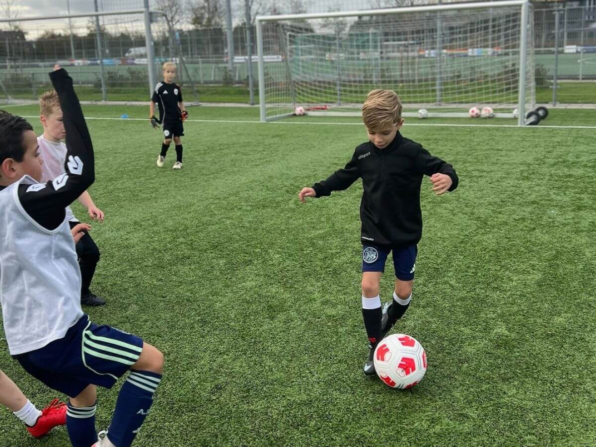 Voetbal training – Dribbelen en passen tijdens het kinderfeestje Kinderen spelen een voetbalpartij en oefenen dribbelen en passen tijdens het kinderfeestje.