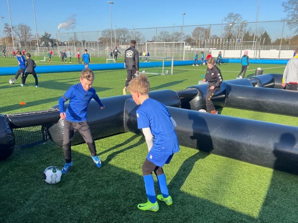 Kinderen vieren hun overwinning met bekers tijdens de seizoensafsluiting van Move For Fun.