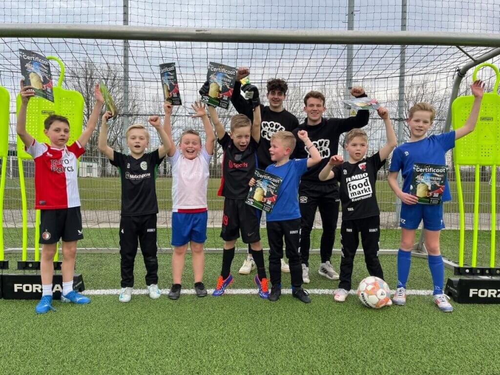 Groepsfoto van kinderen met certificaten na het FIFA voetbal kinderfeestje.