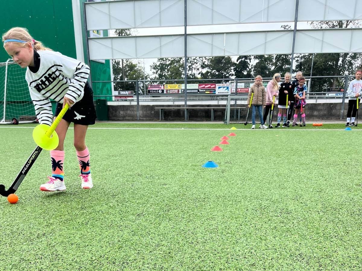 Hockey kinderfeestje – dribbel oefening Meisje doet een dribbel-oefening met stick en bal tijdens het hockey kinderfeestje in Westland