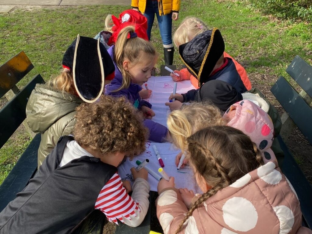Kinderen tekenen op een vlag tijden het feestje