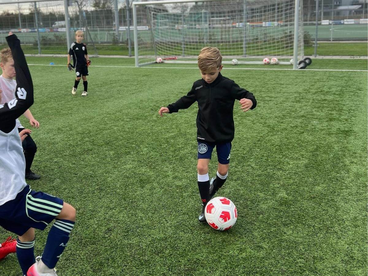 Voetbal activiteit op school & BSO – Move For Fun Kinderen spelen voetbal op sportveld tijdens school- of BSO-activiteit van Move For Fun