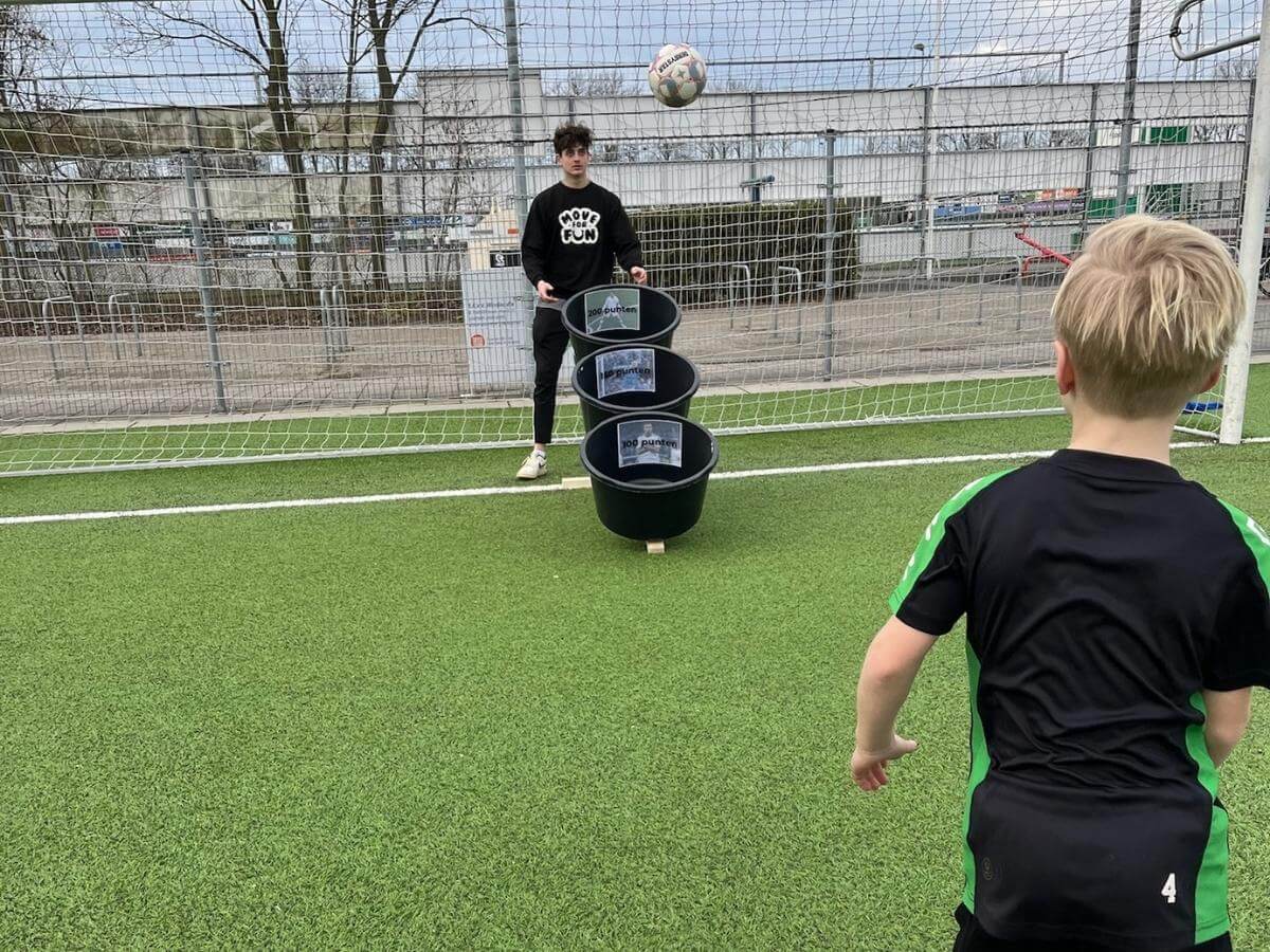 FIFA Voetbal Kinderfeestje – Schietspel met puntenbakken Jongen schiet de bal richting puntenbakken tijdens het FIFA voetbal kinderfeestje in het Westland.