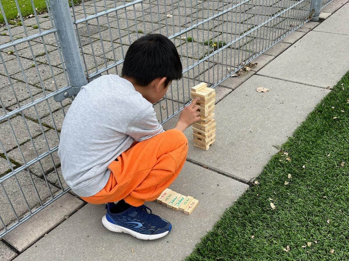 Jenga opdracht Wie is de Mol kinderfeestje Kind voert Jenga zenuwspel uit tijdens Wie is de Mol feestje