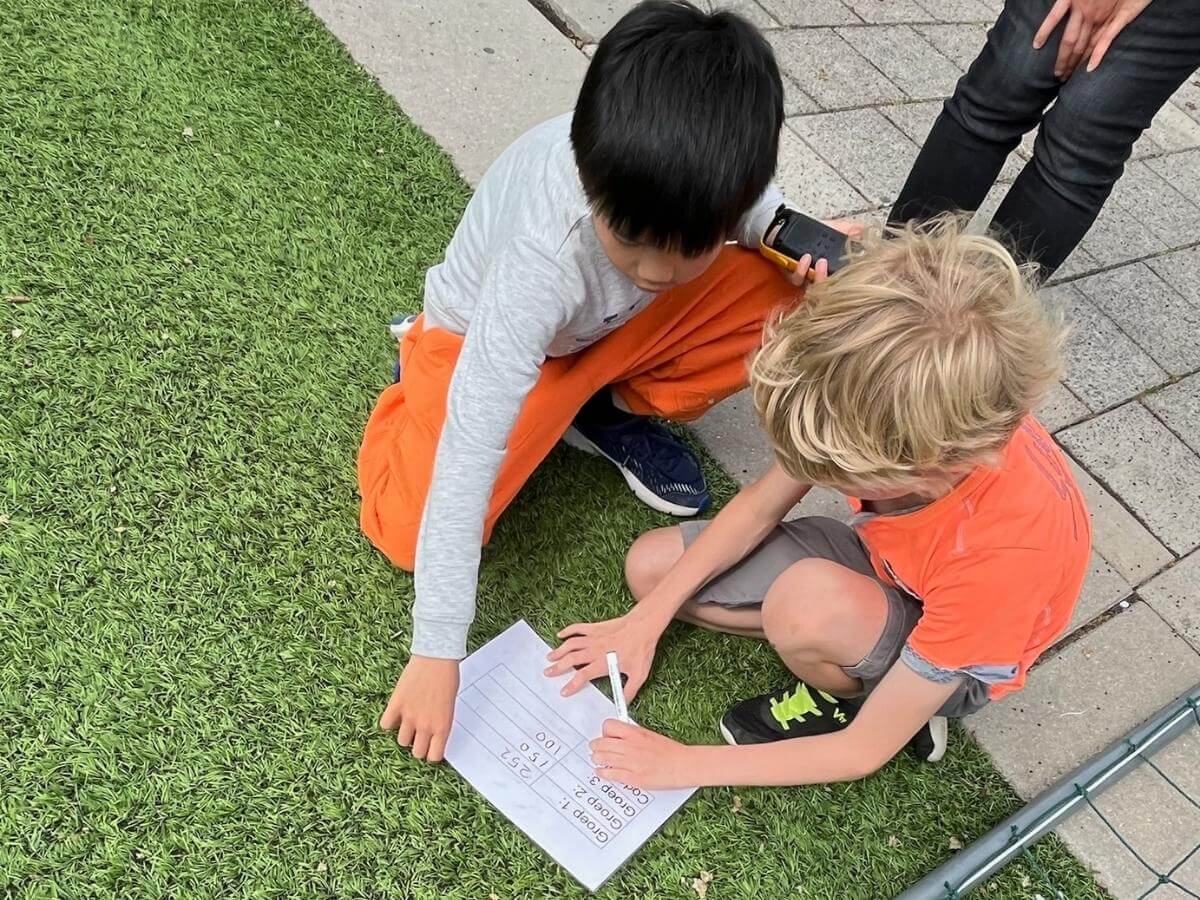 Rekenopdracht Wie is de Mol kinderfeestje Kinderen lossen rekenopdracht op met walkietalkie tijdens Wie is de Mol feestje