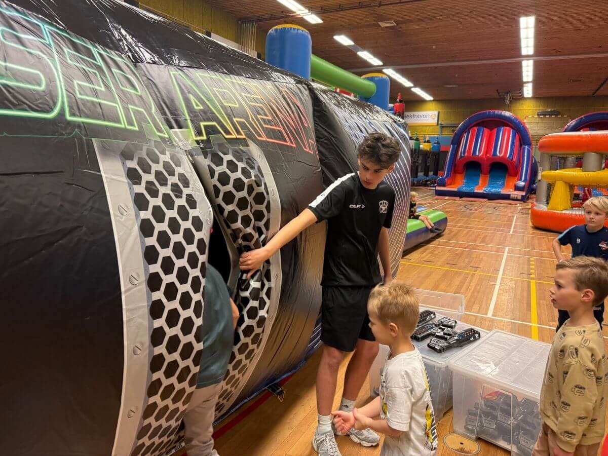 Lasergame arena tijdens sport- en speldag – Move For Fun Begeleider helpt kinderen bij het betreden van de lasergame arena tijdens een sport- en speldag van Move For Fun