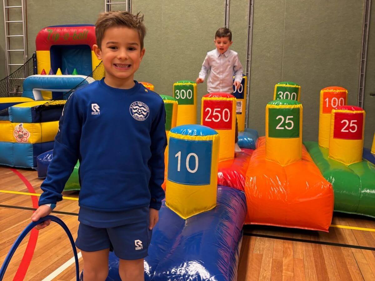 Stokvangen spel voor kinderen tijdens sport- en speldag Kinderen spelen het stokvangen spel tijdens een sport- en speldag in de sporthal met Move For Fun