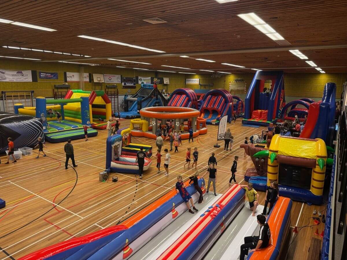 Sport- en speldag met springkussens en stormbanen – Move For Fun Kinderen spelen op stormbanen en springkussens tijdens een sport- en speldag van Move For Fun in een sporthal